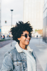 Portrait of young beautiful afro woman outdoor in the city having fun - carefree, serene, thoughtless concept