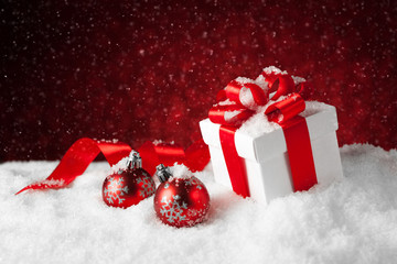 Fototapeta na wymiar Christmas balls and gift box on snow.