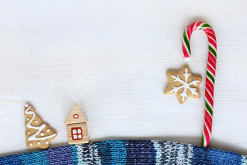 Fototapeta premium street sweet fairy lanterns/ flat layout of a wooden house on a warm scarf and striped candy and cookies top view