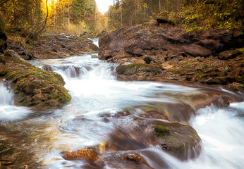 Fototapeta na wymiar Rocky stream flowing through Oytal in autumn, Germany