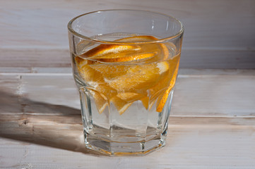 Refreshment Detox water with orange Cocktail with air bubbles and a splash on a white wooden background