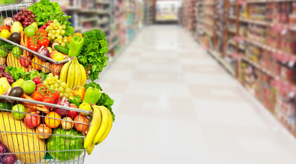 Vegetables and fruits over grocery store background.
