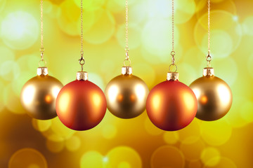 Fototapeta na wymiar Four Christmas baubles on yellow background