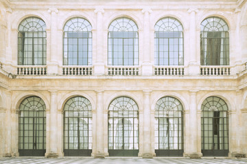 Fototapeta na wymiar Classic architecture. Close up of a classic style facade with large windows and glass doors