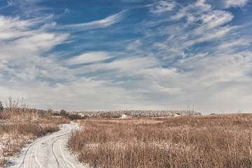 Snow-covered road in winter field