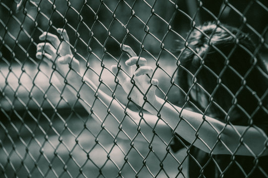 prison women in the cage hand at fence prison in jail, no freedom struggle concept.