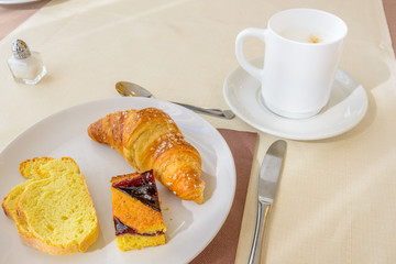 Breakfast including bread, pie, coffee, and croissants.