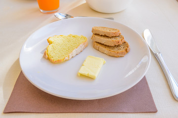 Fototapeta na wymiar Breakfast including coffe, orange juce, bread, and butter.