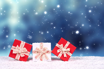 Weihnachtsgeschenke in rot und weiß, winterlicher Hintergrund