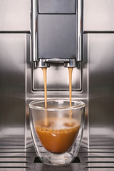 Cup filling from two jets on a modern coffee machine.