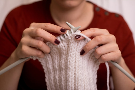 Girl knitting a white scarf