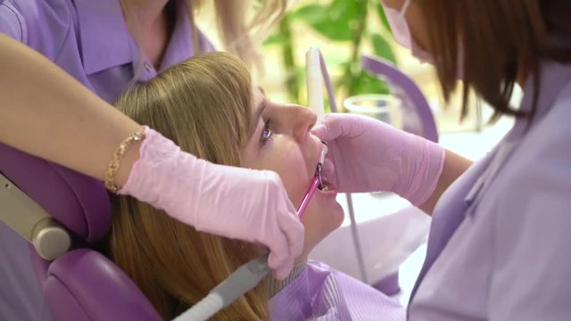 Woman at the dental hygienist and dentist clinic professional tooth whitening and ultrasound cleaning. Odontic and mouth health and hygiene is important part of human life that dentistry help with