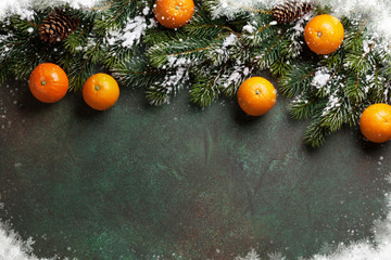 Fototapeta na wymiar Christmas background with snow fir tree and tangerines