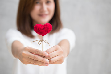 Giving love gift, Asian woman hand hold give beautiful red heart sweet loving symbol of take care or charity help to you.