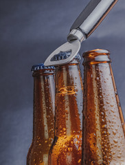 man open fresh cold beer ale bottles with drops and stopper open with bottle opener