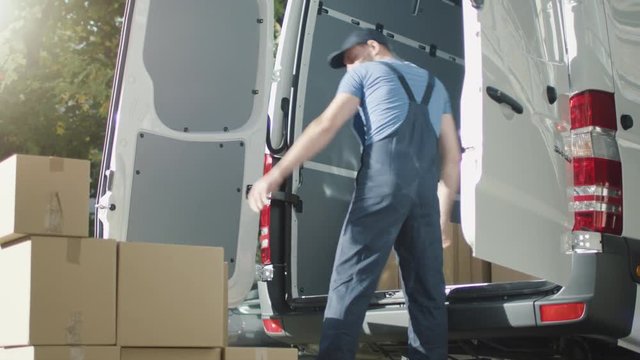 Mover Loads His Van with Cardboard Boxes. Shot on RED Cinema Camera in 4K (UHD).