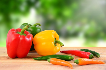 Chili and bell peppers on wooden.
