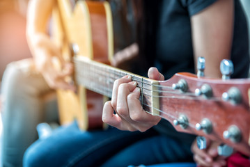Women playing guitar in party,another woman sing a song