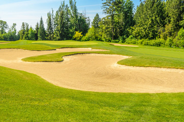 Obraz premium Golf course with gorgeous green and sand bunker