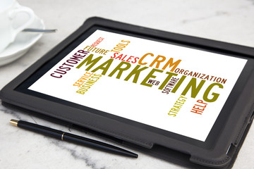 tablet pc with CRM marketing word cloud
