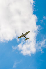Small-engine plane in a blue sky on a background of clouds