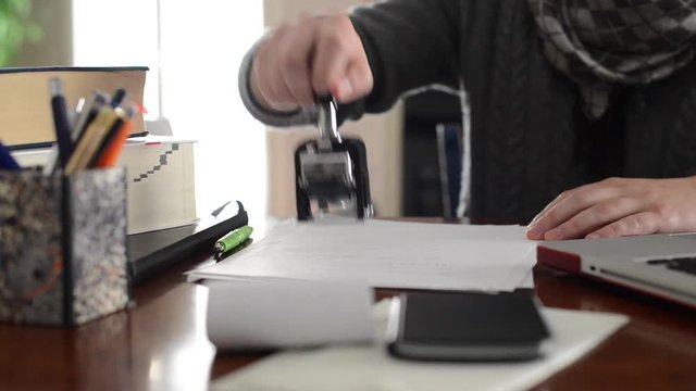 Accountant signing and stamping the documents in the office