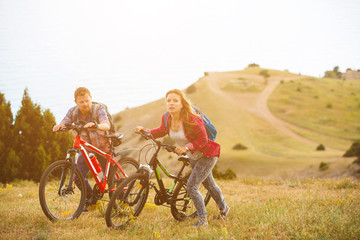young couple  riding bikes in the mountains