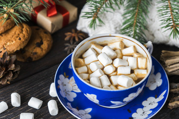 cup of coffee with marshmallows, knitted sweater and christmas decoration