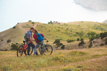 young couple  riding bikes in the mountains