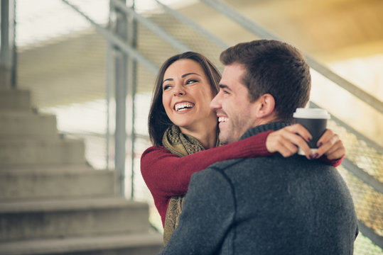 Mixed race couple embracing, smiling and enjoying, posing outdoors