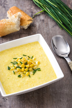 Corn soup in white bowl on wooden background
