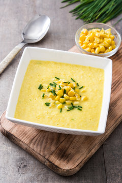 Corn soup in white bowl on wooden background
