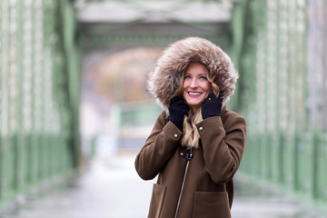 Attractive blonde woman wearing winter jacket on street
