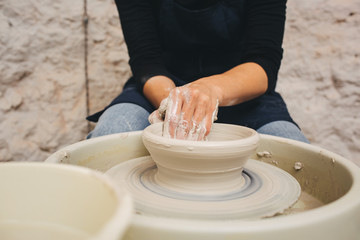 Hands working on pottery wheel