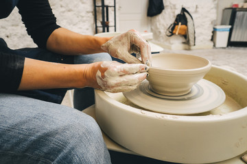 Hands working on pottery wheel
