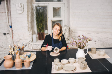 Female Potter creating mug and decor it