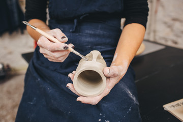 Fototapeta na wymiar Female hands working on mug