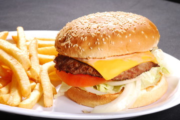 Cheese burger in sesame bun with french fries, tomato, lettuce, onion