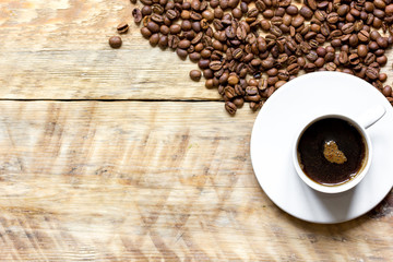 coffee beans on wooden with coffe cup table top view
