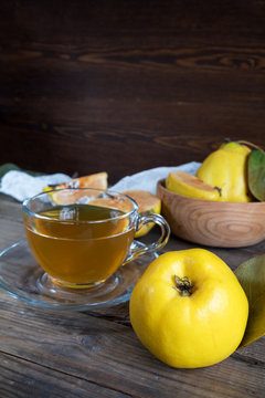 Cup of hot  tea and fresh quince fruit on table