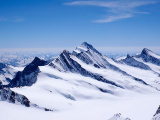 Fototapeta na wymiar mountain guide and client descending a high alpine peak with a gigantic panorama of the Swiss Alps