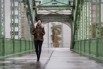 Attractive blonde woman wearing winter jacket walking on street