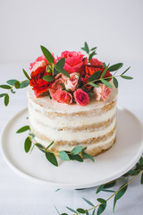 Appetizing wedding cake with flowers in rustic style on white background