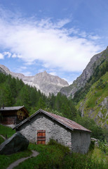 Fototapeta na wymiar a Stone Mountain hut in a narrow valley in the Swiss Alps
