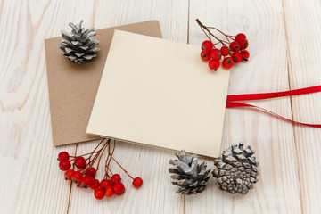 Christmas mokup.Empty cards with rowanberry and cones .White wooden table.Top view