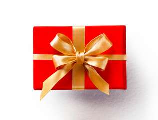 Red gift with golden bow on white background. Close up. Top view. High resolution product, top view