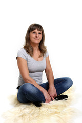 Kobieta siedzi na skórze naturalnej, na białym tle. - obrazy, fototapety, plakaty