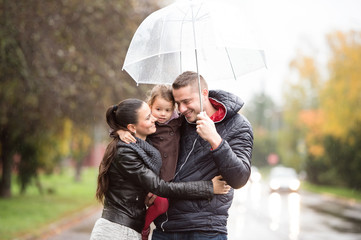 Fototapeta premium Family with daughter under the umbrellas Walk on rainy day.