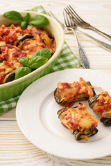 Roasted eggplants stuffed with minced meat and baked with tomatoes and cheese.