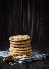 Stack of oatmeal cookies with cranberries and seeds on wooden rustic background